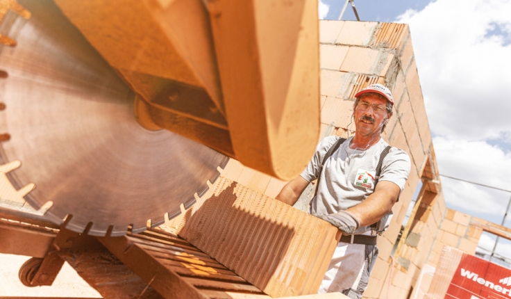 Mitarbeiter mit Schutzbrille an der Steinsäge