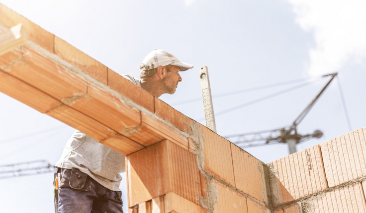 Mitarbeiter auf Fenstersturz prüft mit Wasserwaage